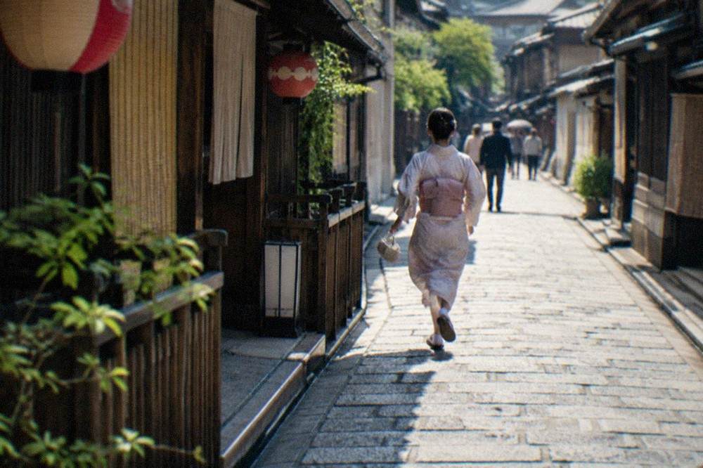 Stone-paved alley with traditional wooden teahouse facades and hanging lanterns in Kyoto