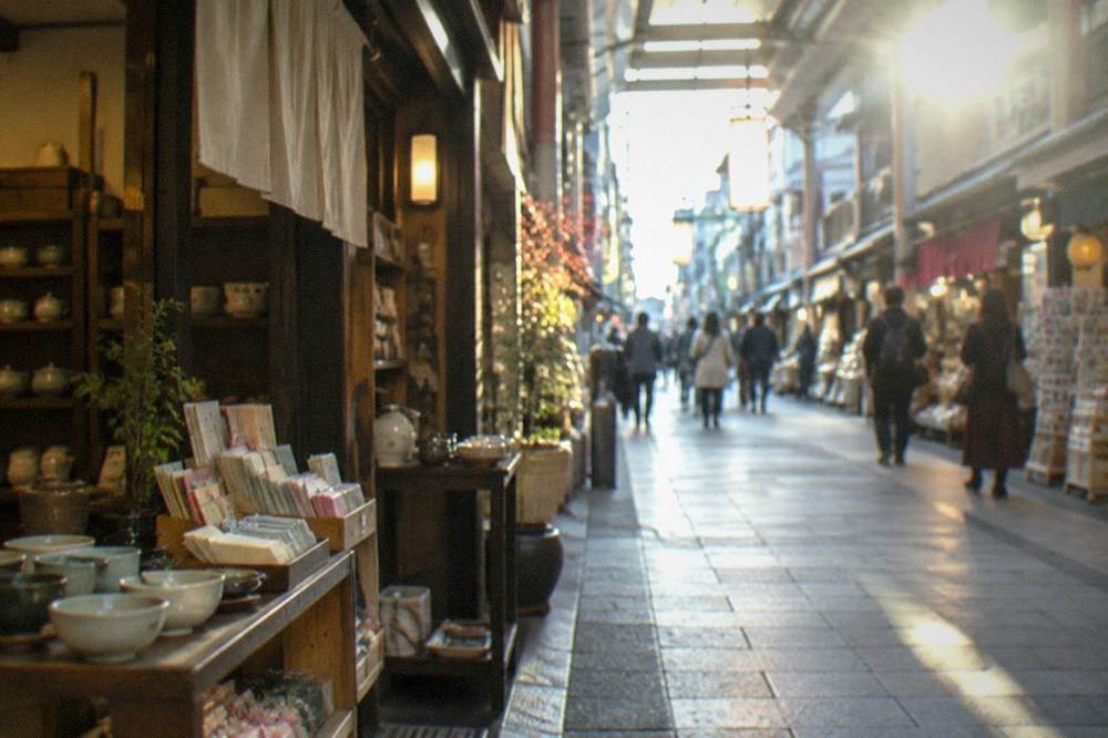 Shopfronts selling tea, ceramics and paper goods inside a Kyoto arcade