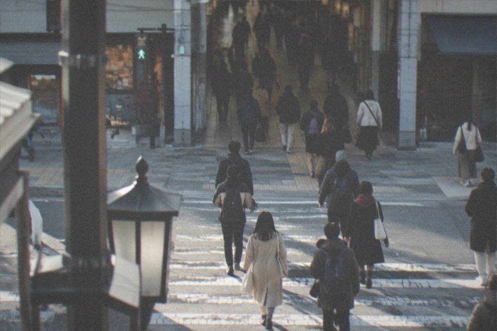 A busy pedestrian crossing on Shijo-dori at the entrance to a covered arcade