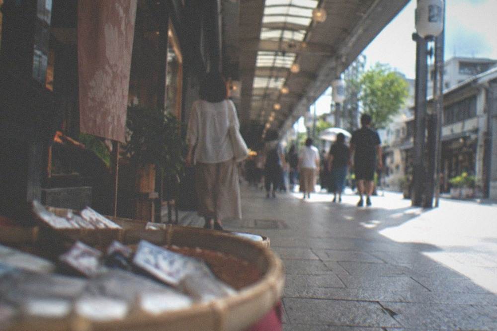 People browsing under the arcade roof on a hot afternoon in downtown Kyoto