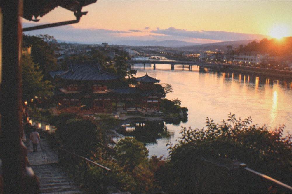 The Uji river at dusk with the town's lights reflected in the water