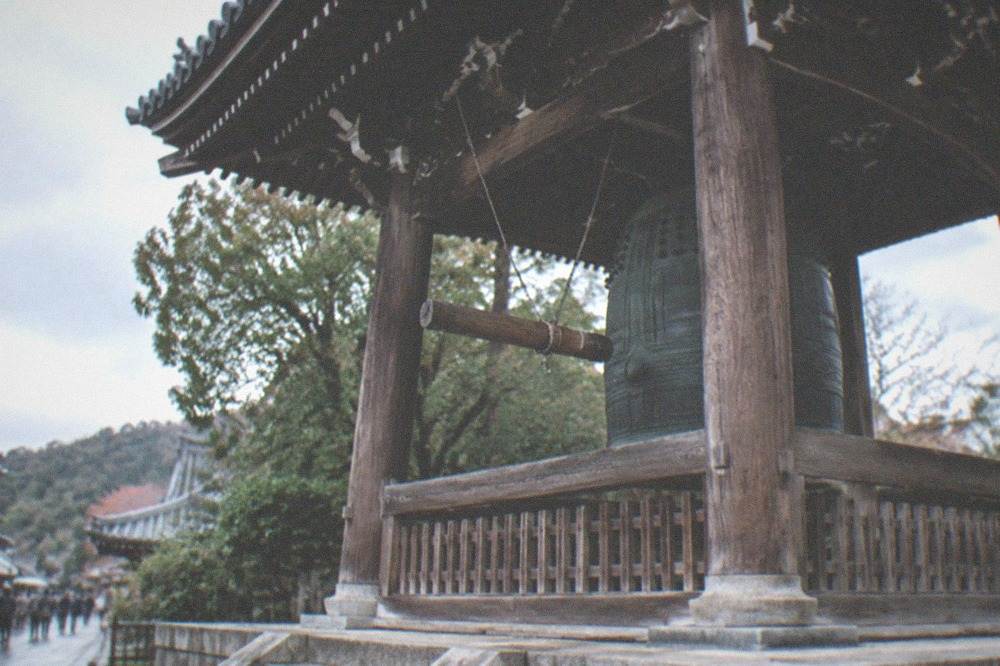 A great bronze temple bell housed in an open wooden bell tower
