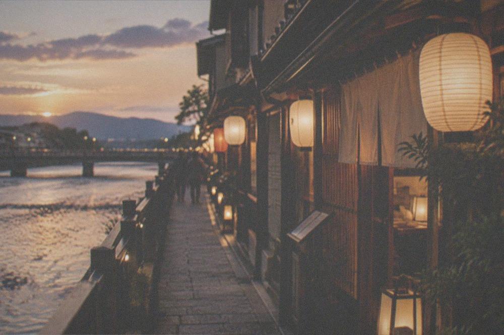 A narrow lantern-lit alley of restaurants beside a river at night