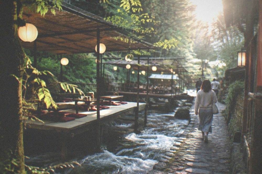 Wooden dining platforms built low over a rushing mountain stream beside a cedar forest