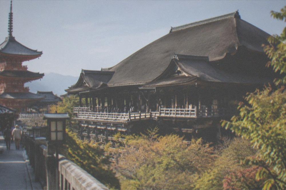 The main hall of Kiyomizu-dera with its wooden stage and tiled roof seen from the pagoda side