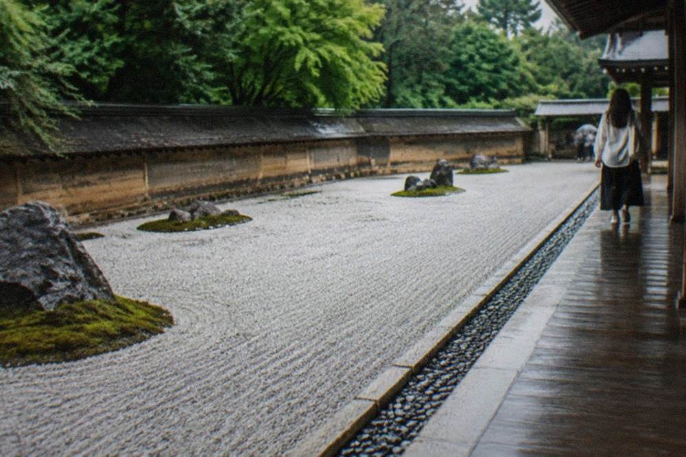 A wide rectangular Zen rock garden of raked white gravel with clusters of dark stones set on mossy islands