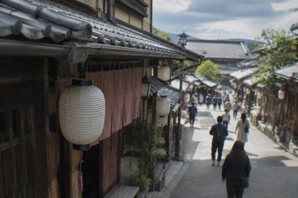 A period film set street with wooden facades and lanterns at a Kyoto theme park