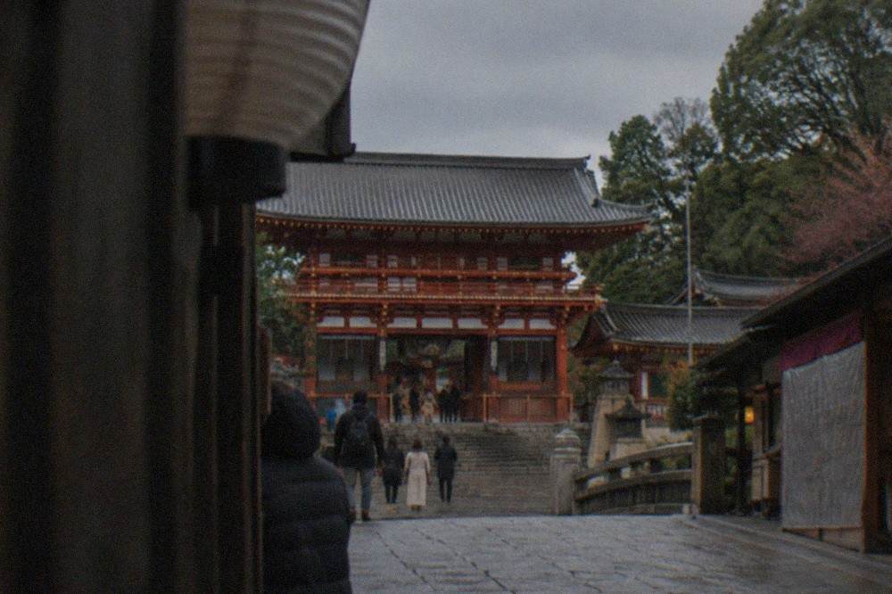 The two-storey west gate of Yasaka Shrine seen from the stone approach in daytime