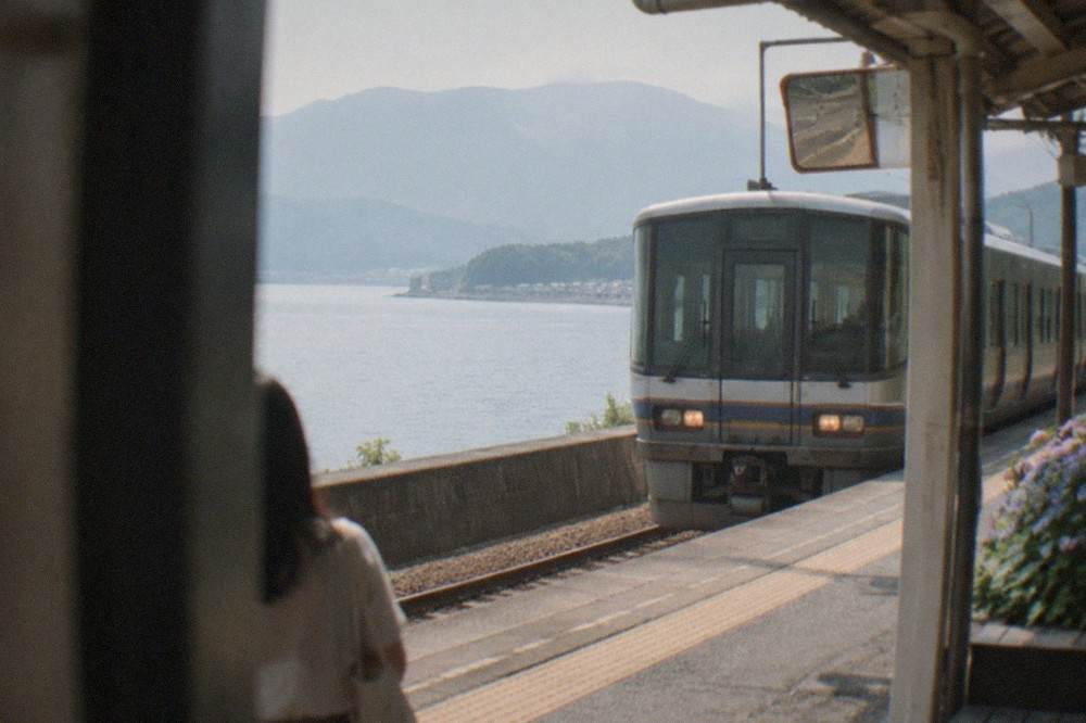A limited express train at a small coastal station platform in northern Kyoto Prefecture