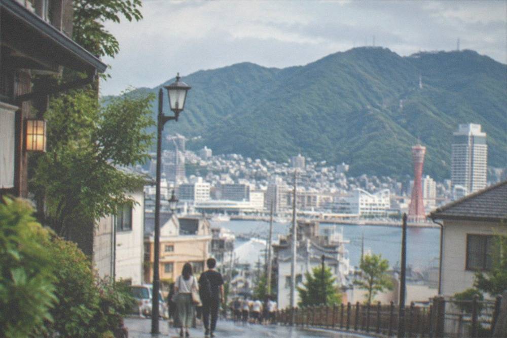 Steep green mountainside rising directly behind dense city buildings in Kobe