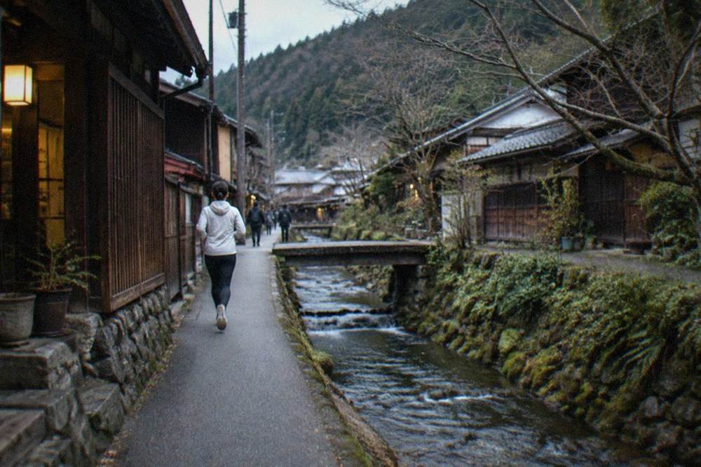 A narrow mountain stream running beside a village street with wooden buildings