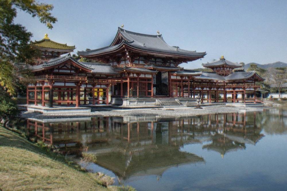 The Phoenix Hall of Byodo-in reflected in its pond under a clear sky