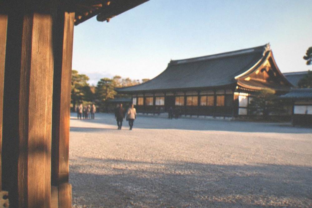 A wide gravel plaza and traditional roofed gate in front of the Kyoto Imperial Palace grounds