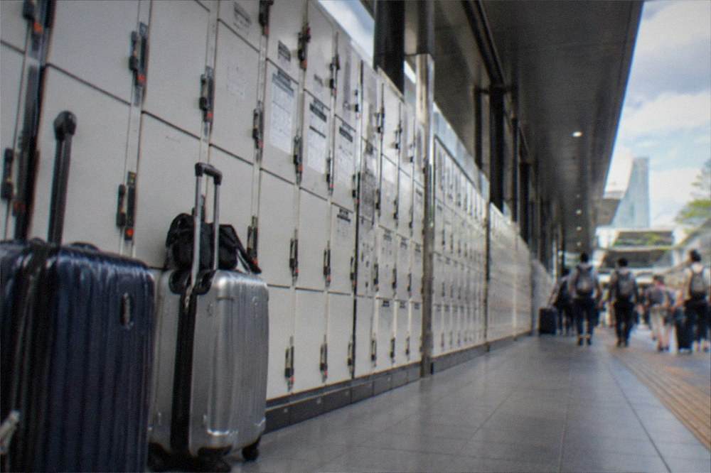 Rows of coin lockers along a station corridor with suitcases nearby
