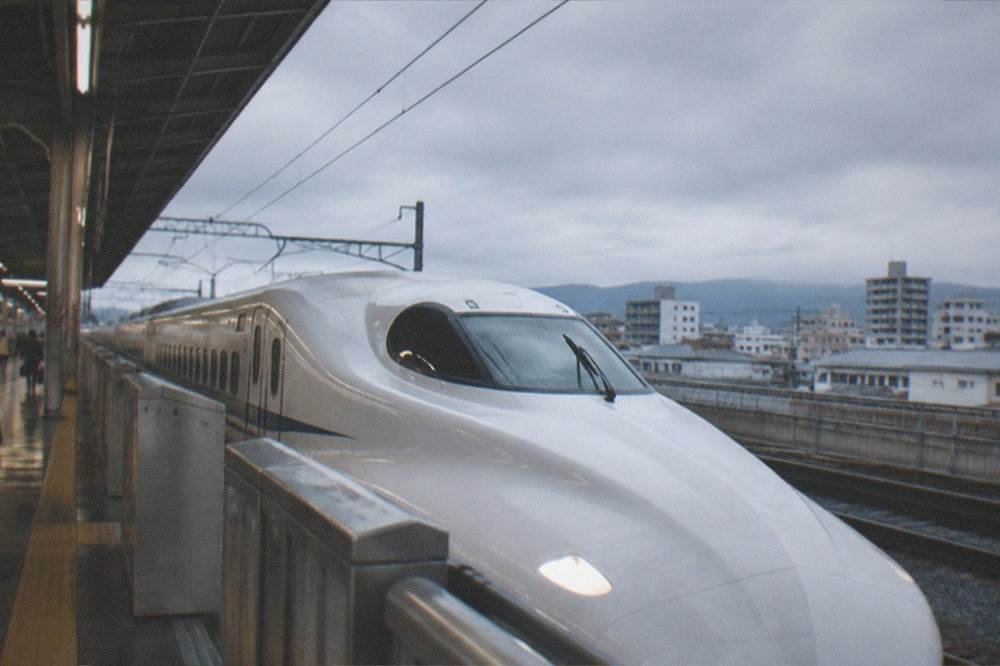 A shinkansen bullet train waiting at a platform inside a large station