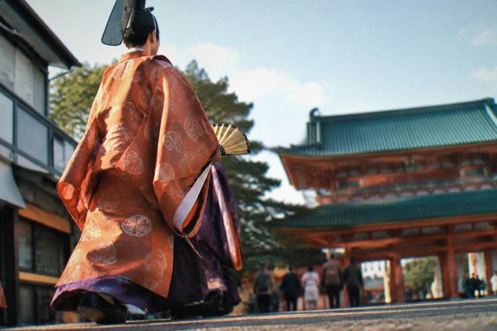 A marcher in Heian period court robes carrying a fan in a Kyoto procession