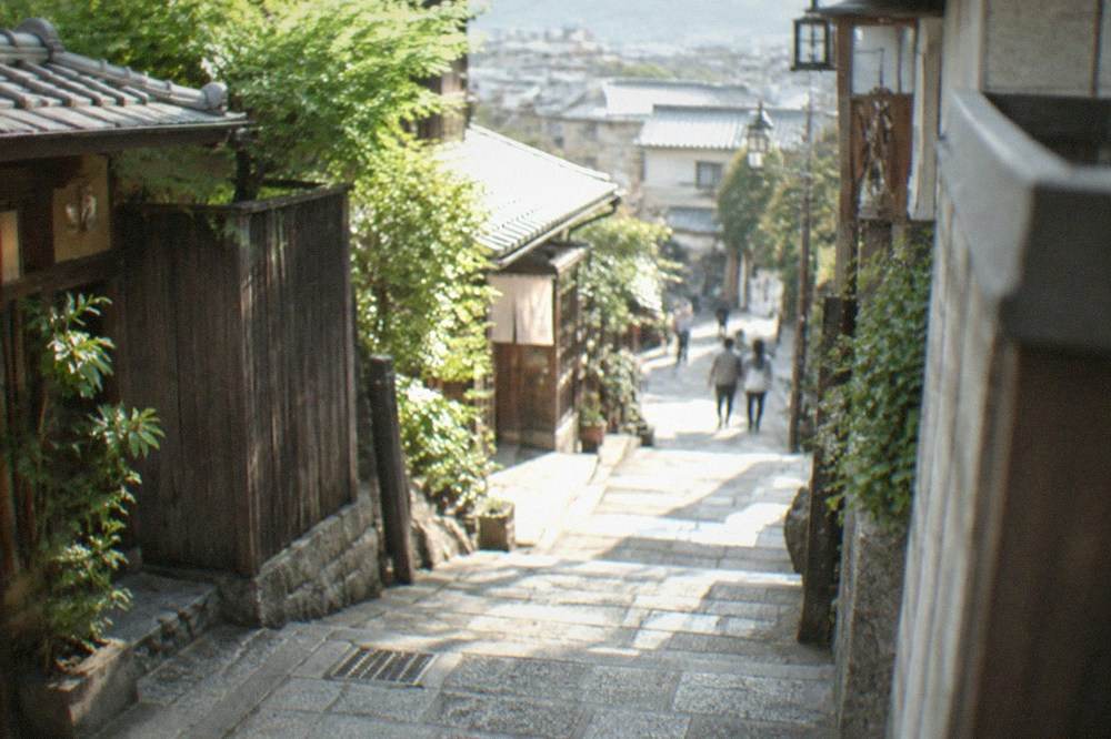 A quiet Kyoto alley in the morning with stone paving and wooden gates