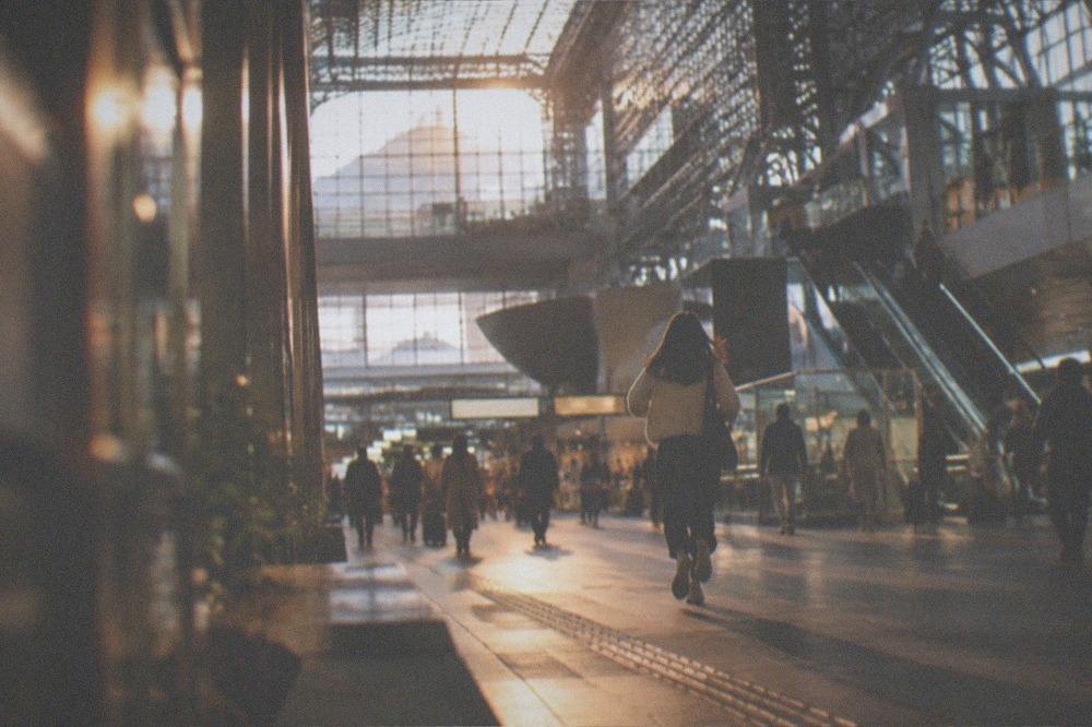 The cavernous multilevel atrium of a large modern railway station with escalators and glass roof