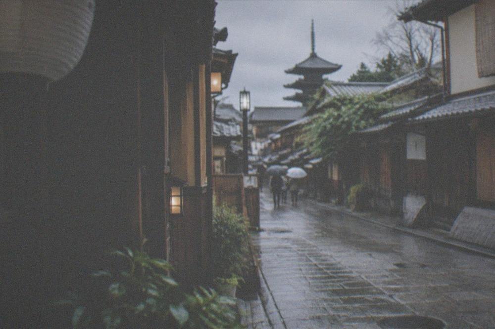 A narrow Gion alley with traditional wooden facades and a no-photography sign posted