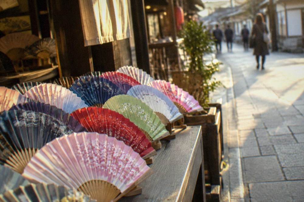 Folding fans in many colours fanned out across a shop counter
