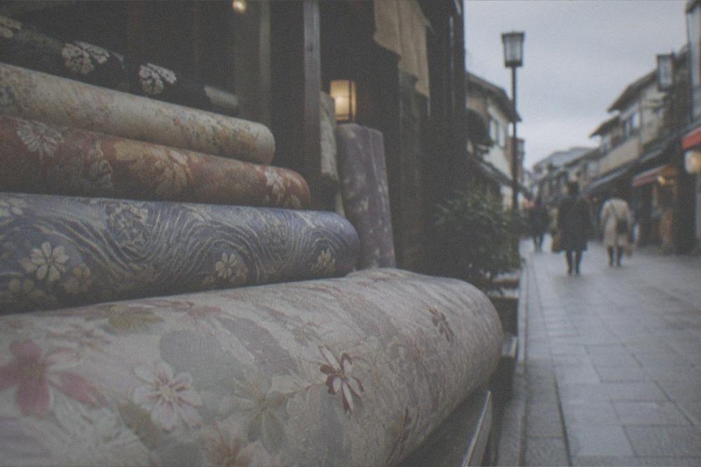 Rolls of patterned woven silk fabric stacked in a textile shop