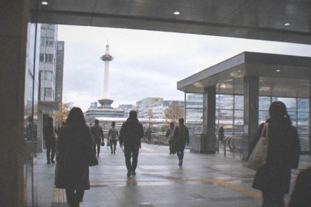 A clean, brightly lit Kyoto subway concourse with a high ceiling and wide walkways