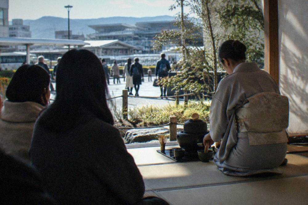 Guests seated on tatami watching a tea host prepare matcha
