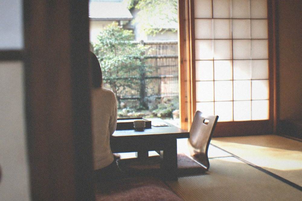 A traditional Kyoto ryokan room with tatami flooring, paper screens and low furniture