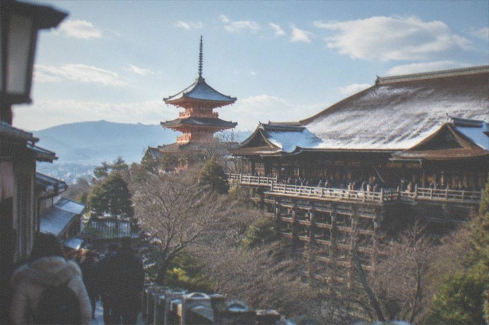 Kiyomizu-dera's wooden stage and pagoda dusted with light snow under a clear winter sky