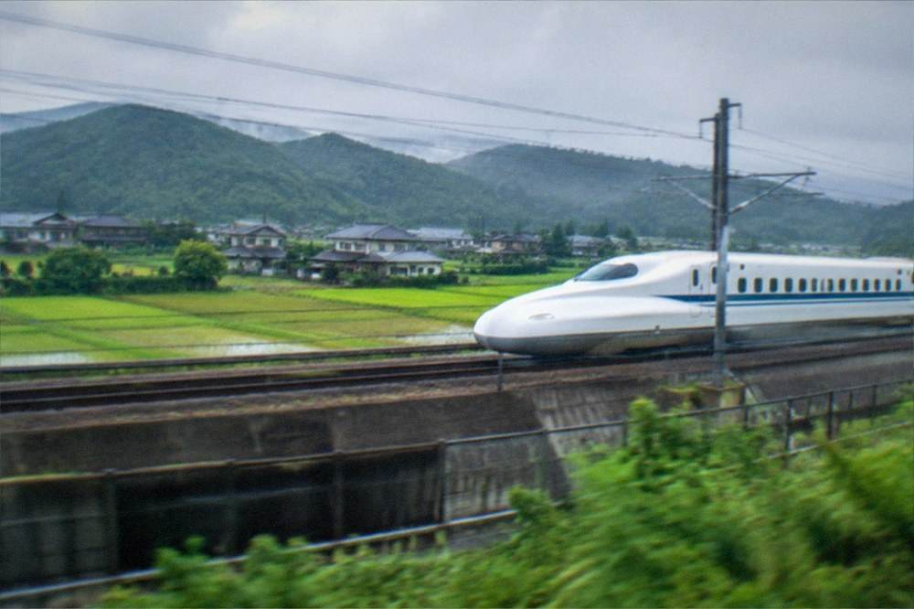 A rapid train travelling through countryside between Kyoto and Nara