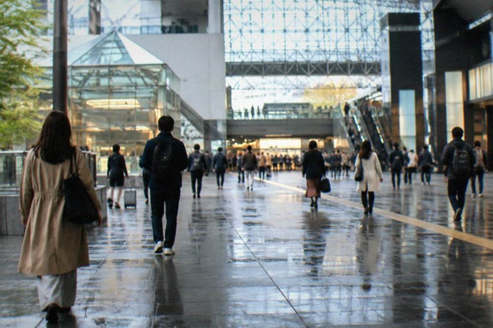 The broad glass concourse of Kyoto Station with travelers moving through the central hall