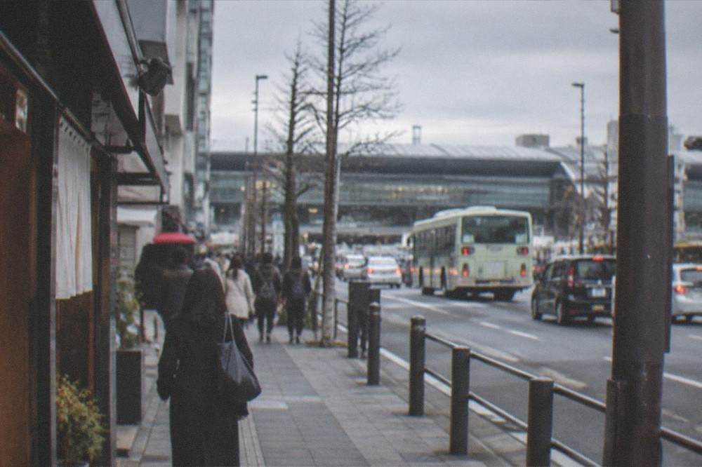 A train platform with a departure board and morning commuters