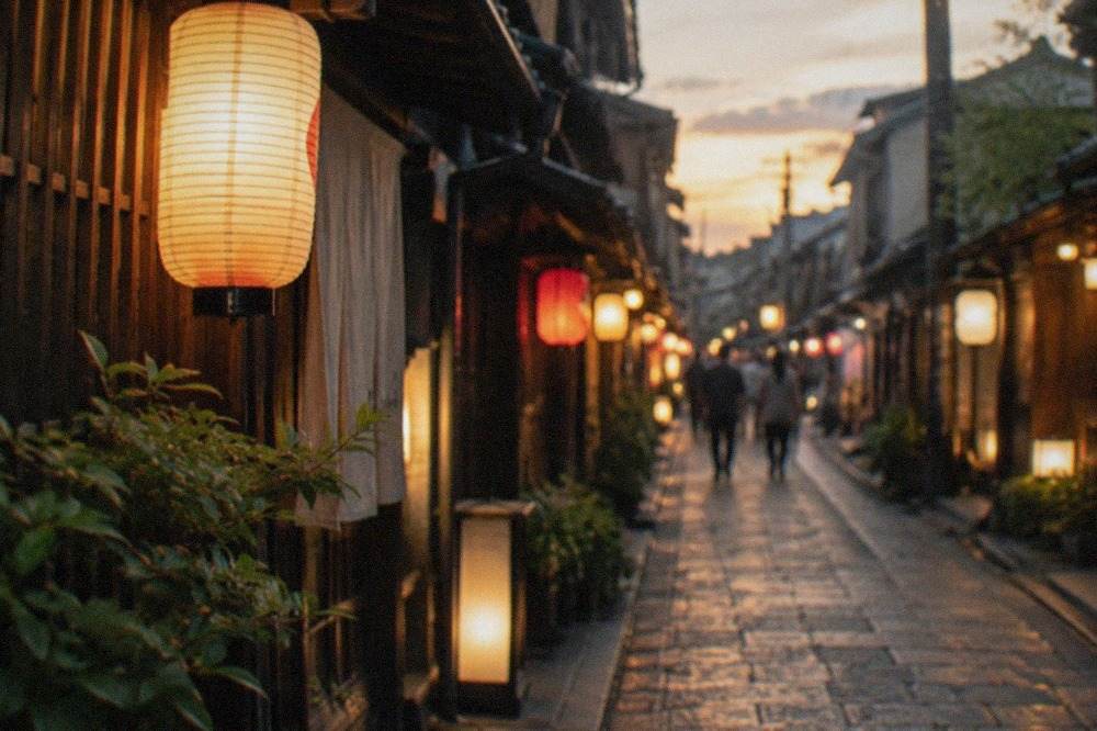 Lanterns glowing along a narrow stone street in Kyoto at dusk