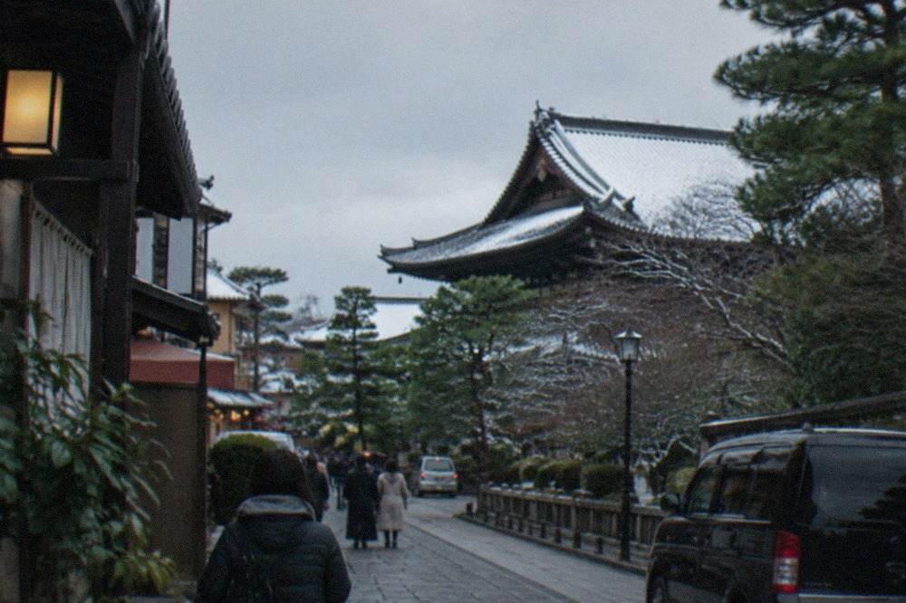 A snow-dusted temple roof in Kyoto under a pale winter sky