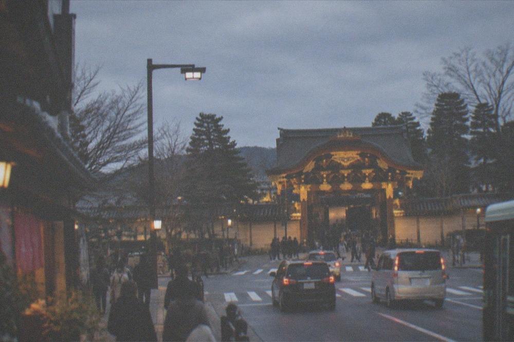 The illuminated gate of Nijo-jo Castle seen from the street at dusk in winter