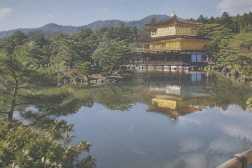 The golden pavilion of Kinkaku-ji reflected in the pond above the trees